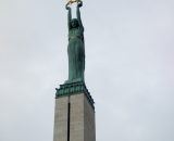 Pomnik Wolności, 9 – metrowa postać kobiety dzierży w dłoniach trzy złote gwiazdy symbolizujące Inflanty, Łatgalię i Kurlandię